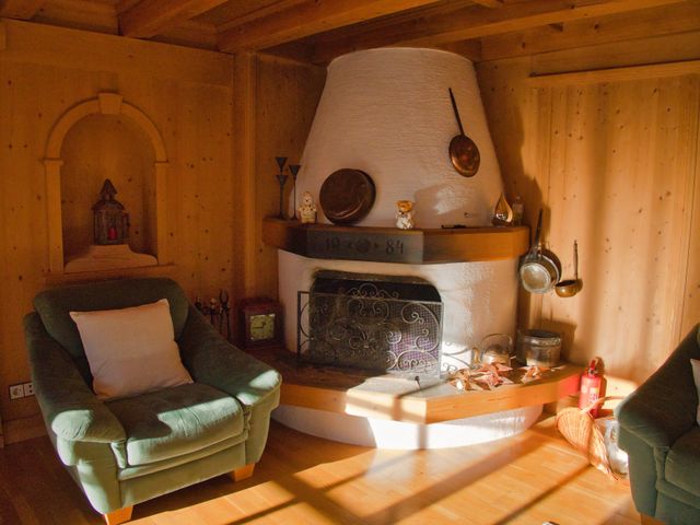 Offener Kamin im Wohnzimmer mit Sessel