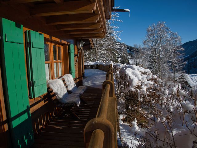 Verschneiter Balkon mit grünen Fensterläden und Bergblick