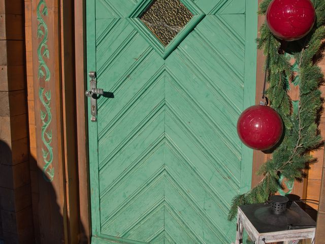 Groene voordeur met deurmat en rode kerstballen