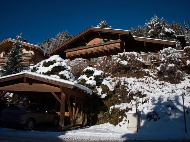 Chalet met carport in de besneeuwde tuin