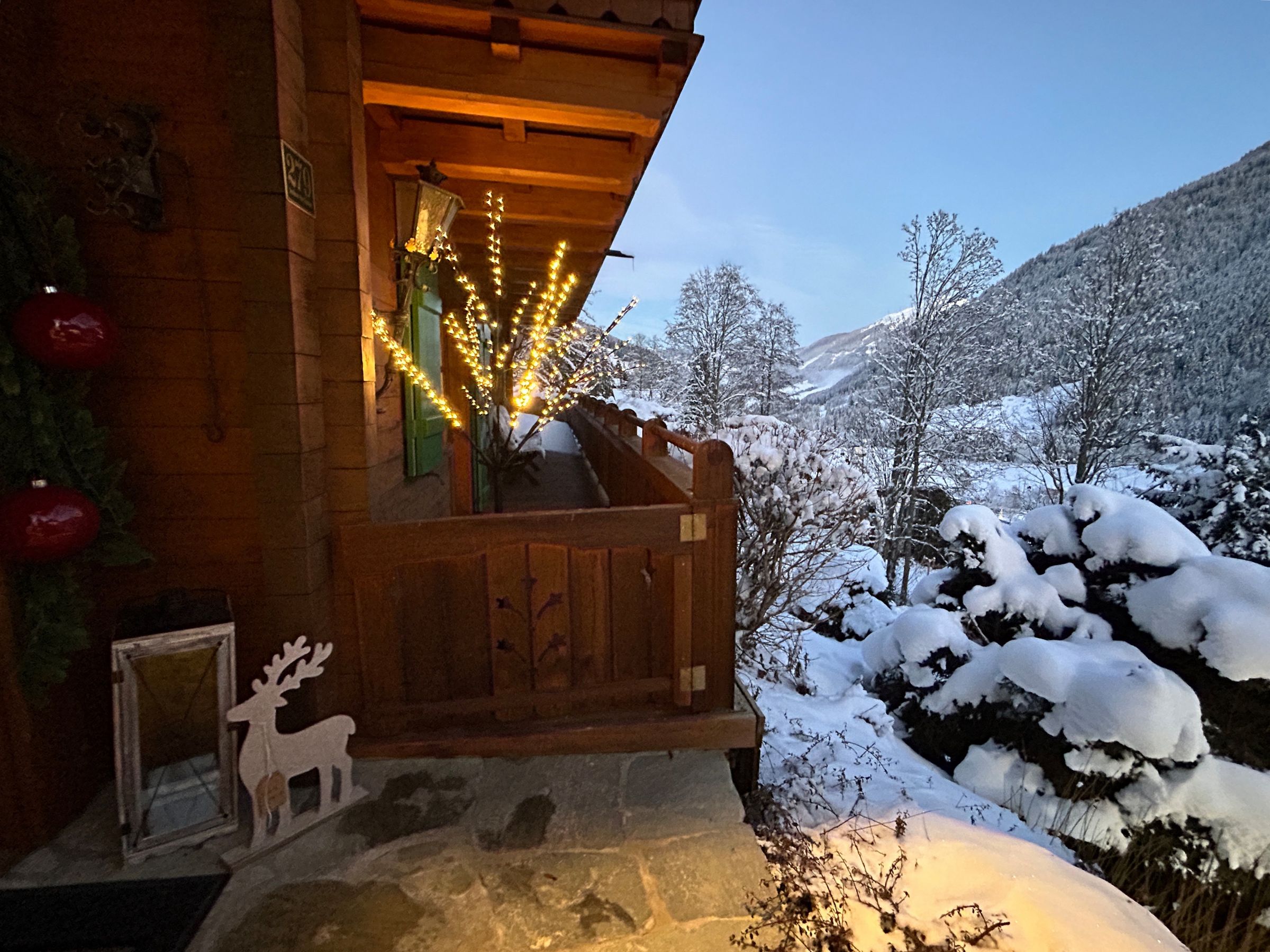 Beleuchteter Eingangsbereich mit Blick ins verschneite Tal