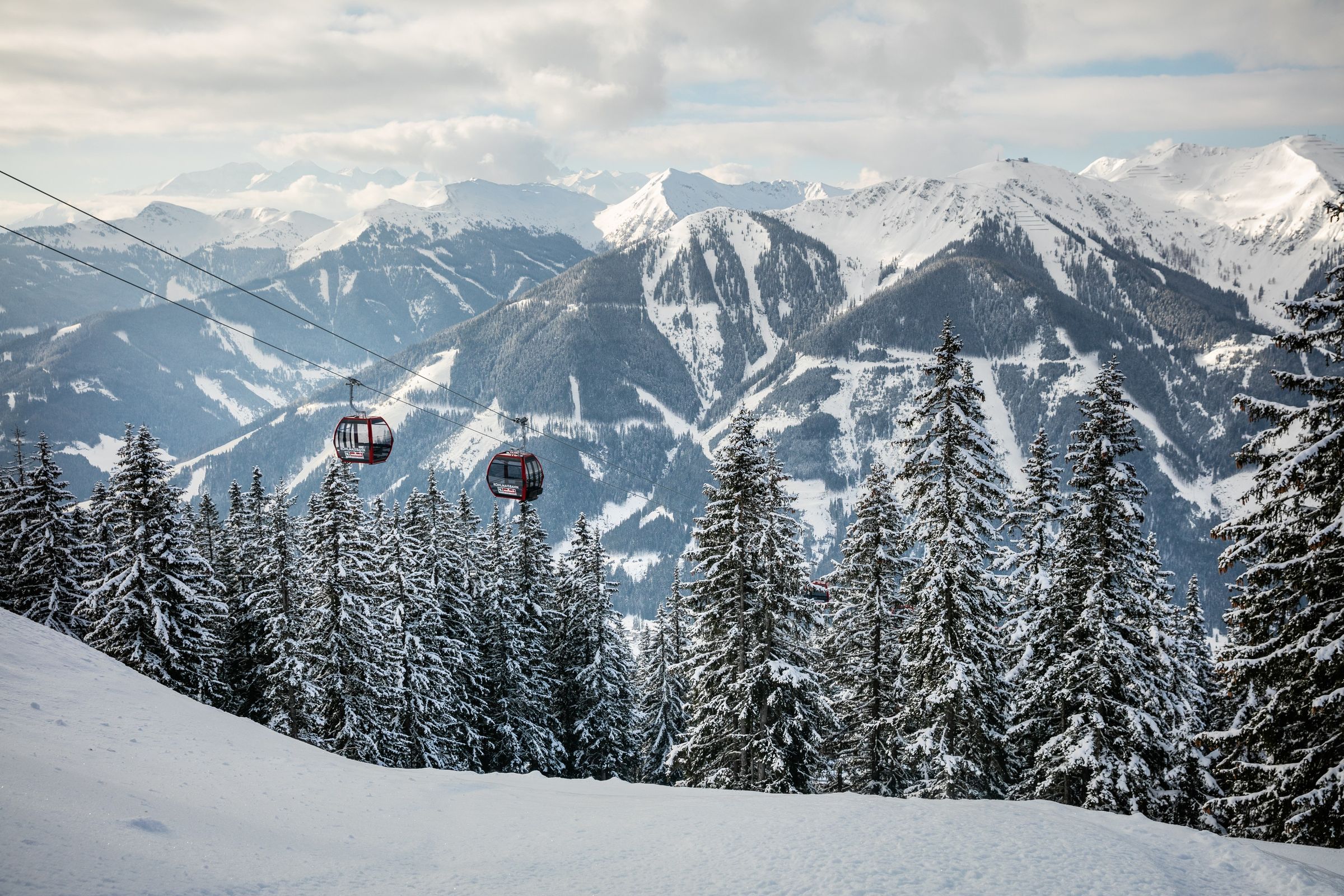 Gondelbahn über verschneiten Wäldern im Skicircus